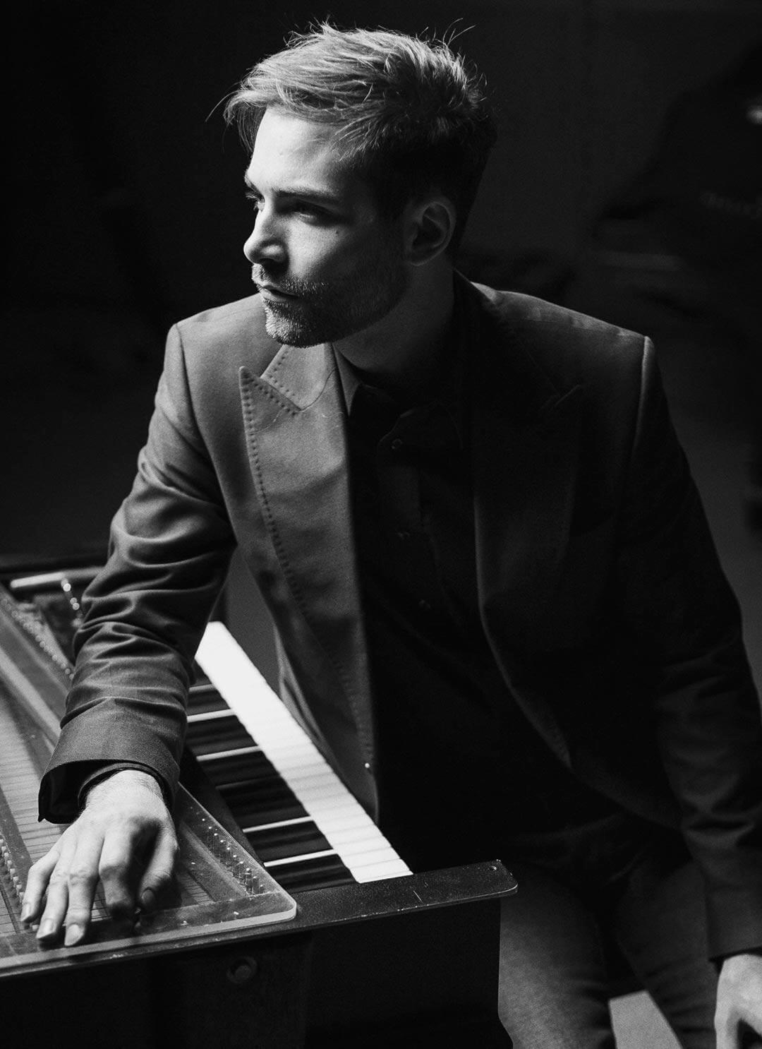 Black and white photo of Charles McDonald sitting at a piano.